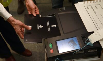 A sample voter card being used to demonstrate the voting process as it's inserted into a new electronic tabulator that people can expect to see in most voting areas during this year's provincial election during a press conference at the Elections BC office in Victoria, B.C., on Wednesday, Sept. 25, 2024. THE CANADIAN PRESS/Chad Hipolito