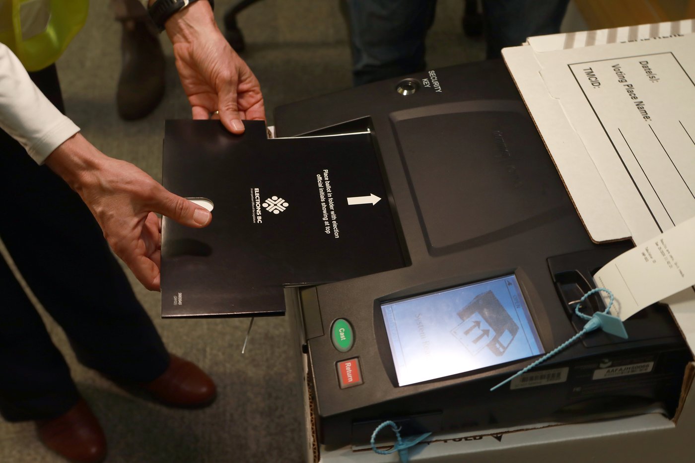 A sample voter card being used to demonstrate the voting process as it's inserted into a new electronic tabulator that people can expect to see in most voting areas during this year's provincial election during a press conference at the Elections BC office in Victoria, B.C., on Wednesday, Sept. 25, 2024. THE CANADIAN PRESS/Chad Hipolito