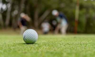 A golf ball is visible on a golf course.