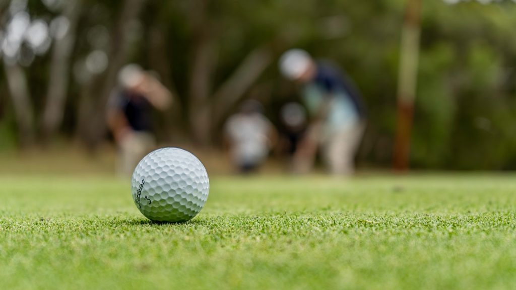 A golf ball is visible on a golf course.