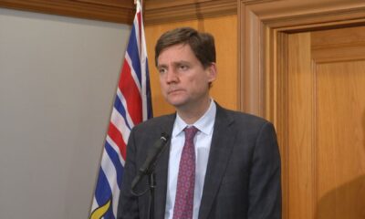 Premier David Eby speaks into a microphone