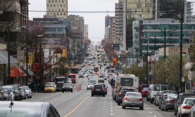 Cars drive down Broadway in Vancouver, with buildings lining either side of the road