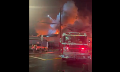 Flames can be seen as fire crews battle a fire at the Super Grocer and Pharmacy in the city's Steveston neighbourhood Friday evening.