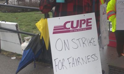 A CUPE 4500 member holds up a sign at a picket line after a 48-hour strike, halting bus and SeaBus services, began the morning of Monday, Jan. 22, 2024.