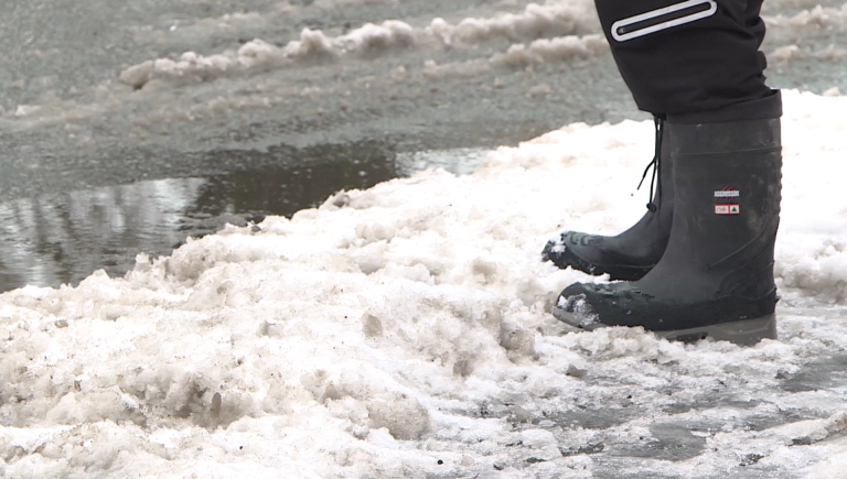 A child stands on snow at the edge of a road after a storm in Vancouver