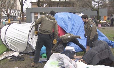 City of Vancouver Park Rangers and Vancouver Police officers dismantle tents at Oppenheimer Park in Vancouver