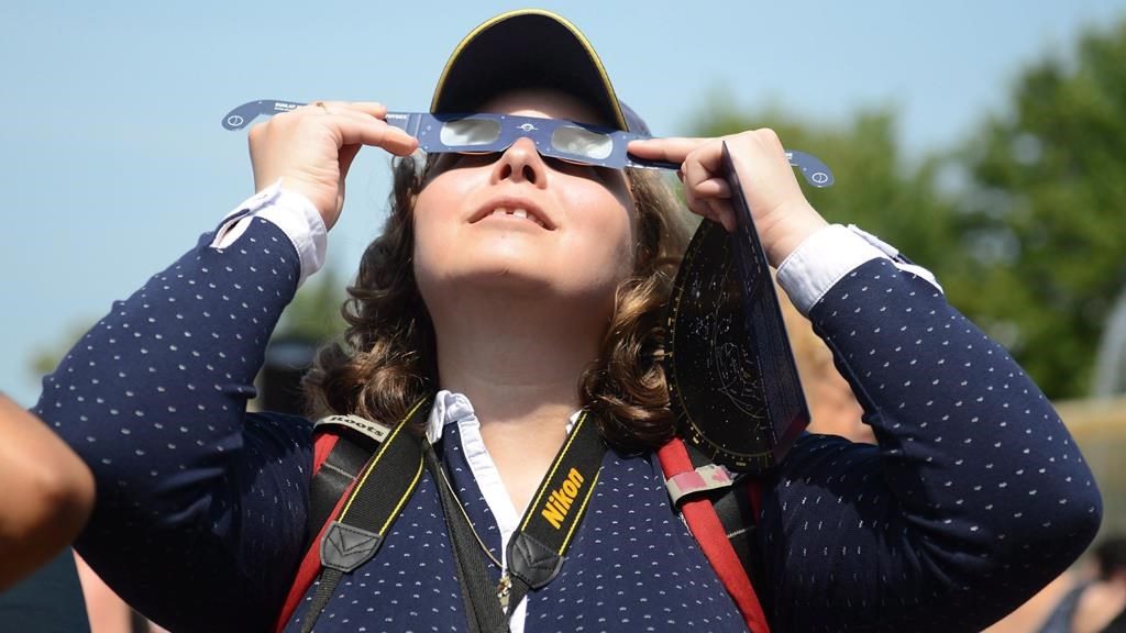 Observers watch a solar eclipse at the Canadian National Exhibition in Toronto on Aug. 21, 2017