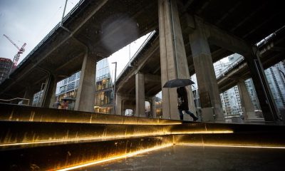 A person carries an umbrella as heavy rain falls in Vancouver, B.C., Tuesday, Jan. 5, 2021. Balmy weather and a series of rainstorms forecast for British Columbia’s South Coast have set off flood advisories for rivers, streams and low-lying areas.