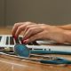 person sitting while using laptop computer and green stethoscope near