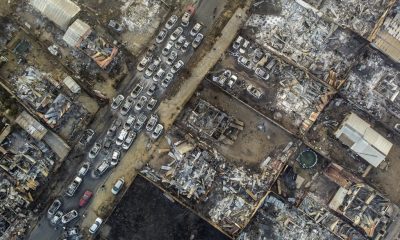 Burnt cars lie on a street after a forest fire reached Villa Independencia neighborhood in Vina del Mar, Chile, Saturday, Feb. 3, 2024.