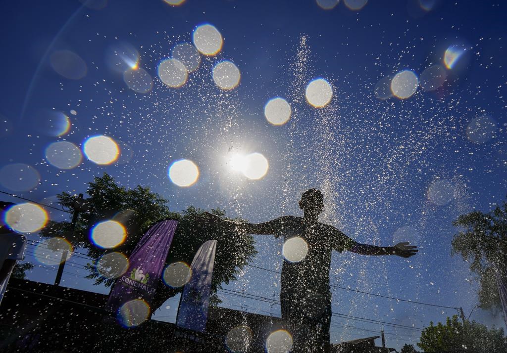 FILE - A youth cools off at the "Parque de Agua" public water park on a hot summer day in Santiago, Chile, Jan. 31, 2024