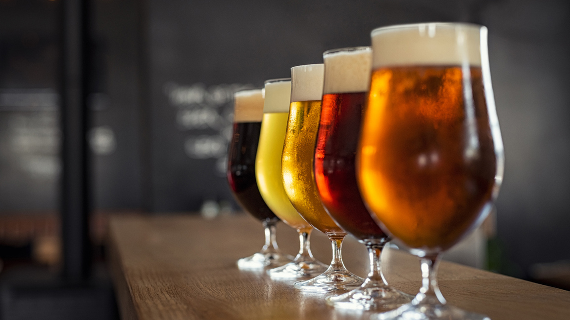 Beer glasses are seen on a bar counter