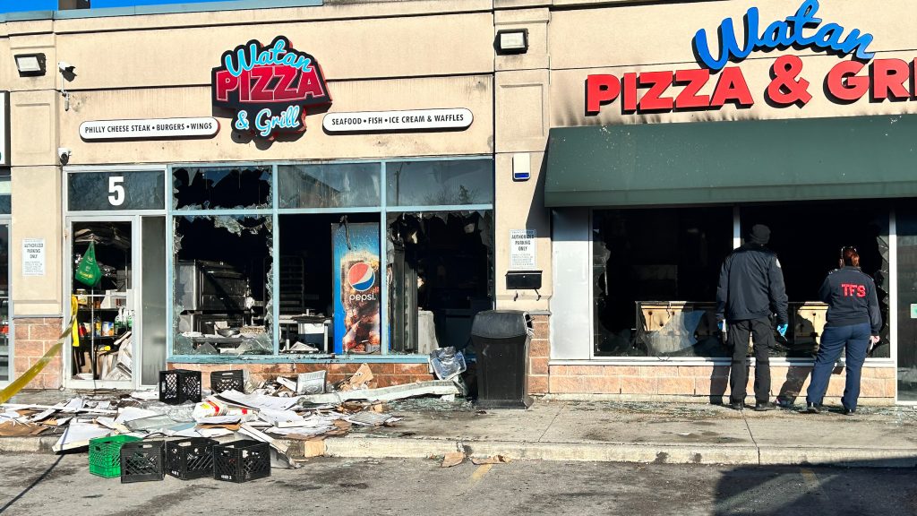 Toronto fire officials inspect the damage at a restaurant on Overlea Boulevard