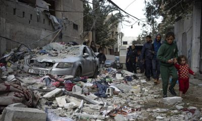 Palestinians look at the destruction after an Israeli airstrike in Rafah