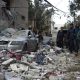 Palestinians look at the destruction after an Israeli airstrike in Rafah