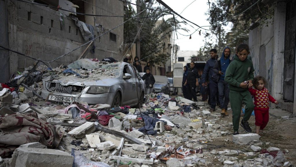 Palestinians look at the destruction after an Israeli airstrike in Rafah