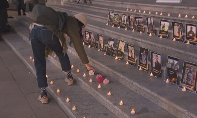 A person places a flower on the steps of the Vancouver Art Gallery