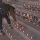 A person places a flower on the steps of the Vancouver Art Gallery