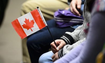 A new Canadian holds a flag as she takes part in a citizenship ceremony on Parliament Hill in Ottawa on April 17, 2019, to mark the 37th anniversary of the Canadian Charter of Rights and Freedoms