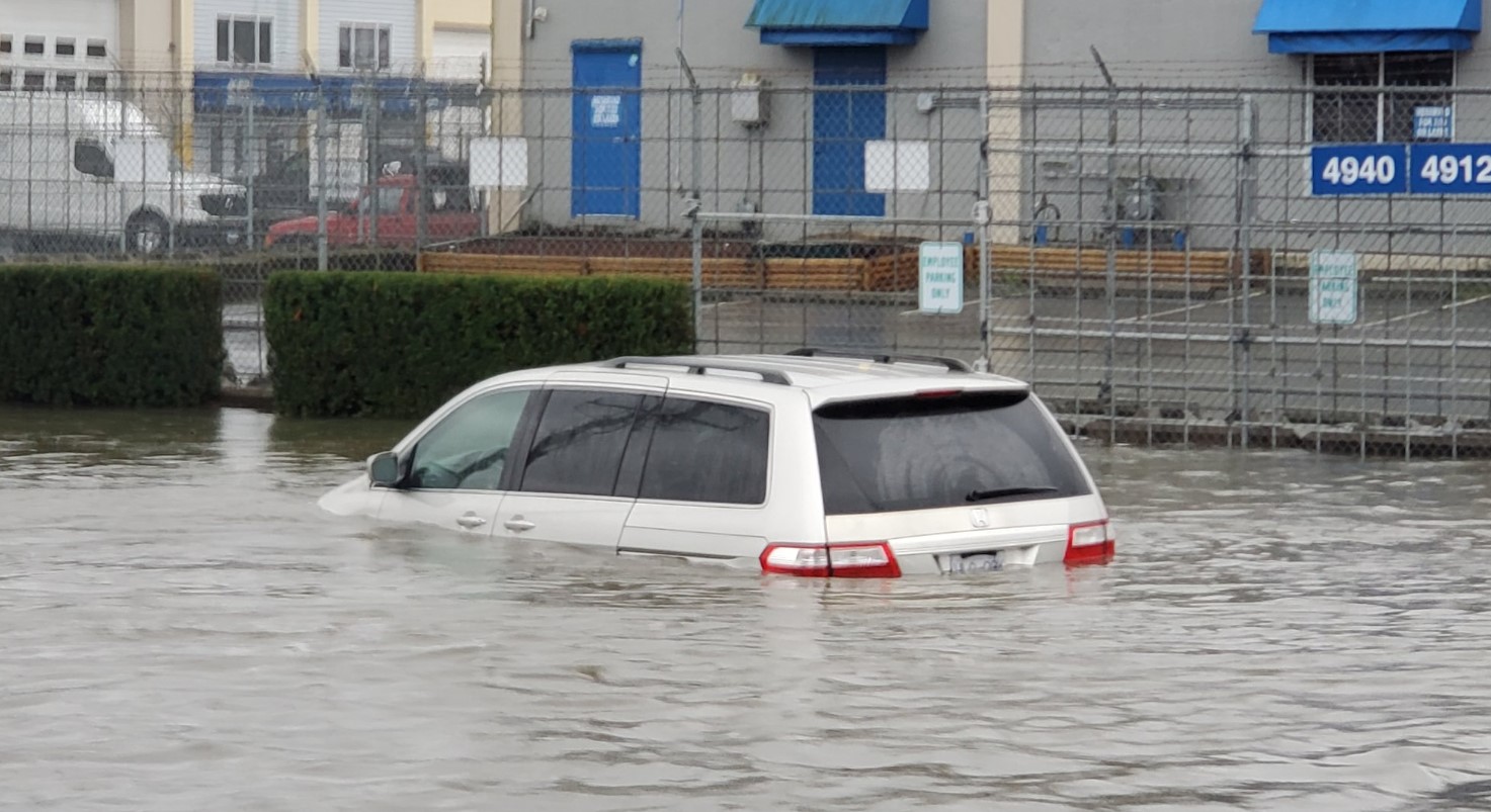 A vehicle is seen partially submerged in a flooded area near Still Creek Drive in Burnaby on Oct. 19, 2024.