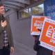 David eby speaks with people holding electoral signs