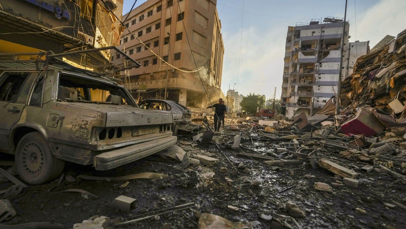 Residents run for cover following an Israeli airstrike in Dahiyeh, Beirut, Lebanon