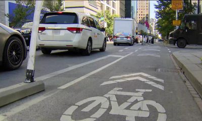 A designated cycling lane is seen on a busy street in downtown Toronto.