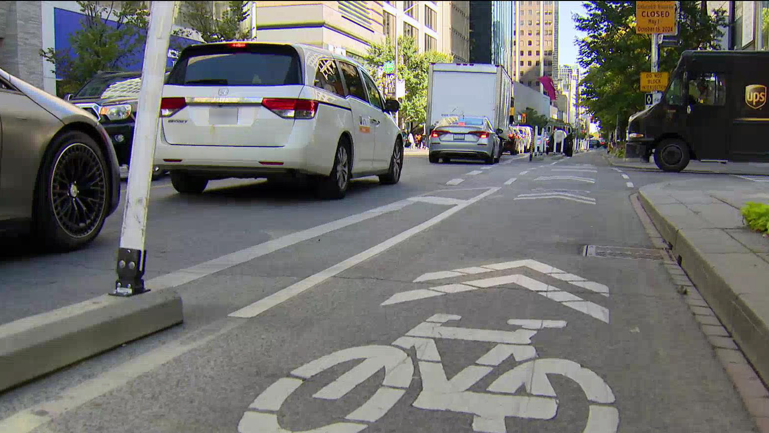 A designated cycling lane is seen on a busy street in downtown Toronto.