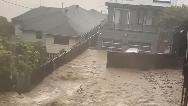 Flood waters pour over a yard in Deep Cove during an atmospheric river weather event Oct. 19, 2024.