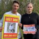 The Gildings pose for a photo, holding posters for their missing dog