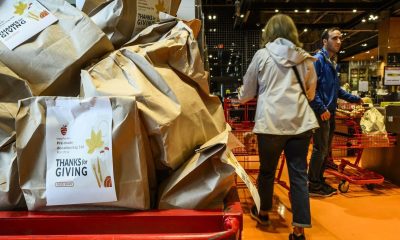 A cart is filled with pre-filled bags of food, during a Thanksgiving food drive