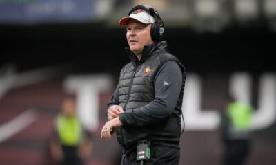 Rick Campbell stands on a football field