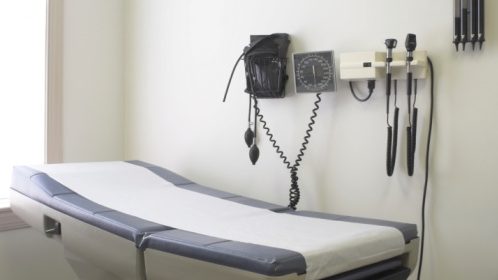 A table at a doctor's office with instruments on the wall