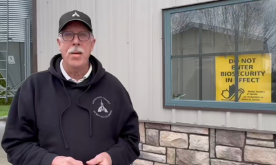 Ian Paton stands in front of a quarantine sign