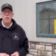 Ian Paton stands in front of a quarantine sign