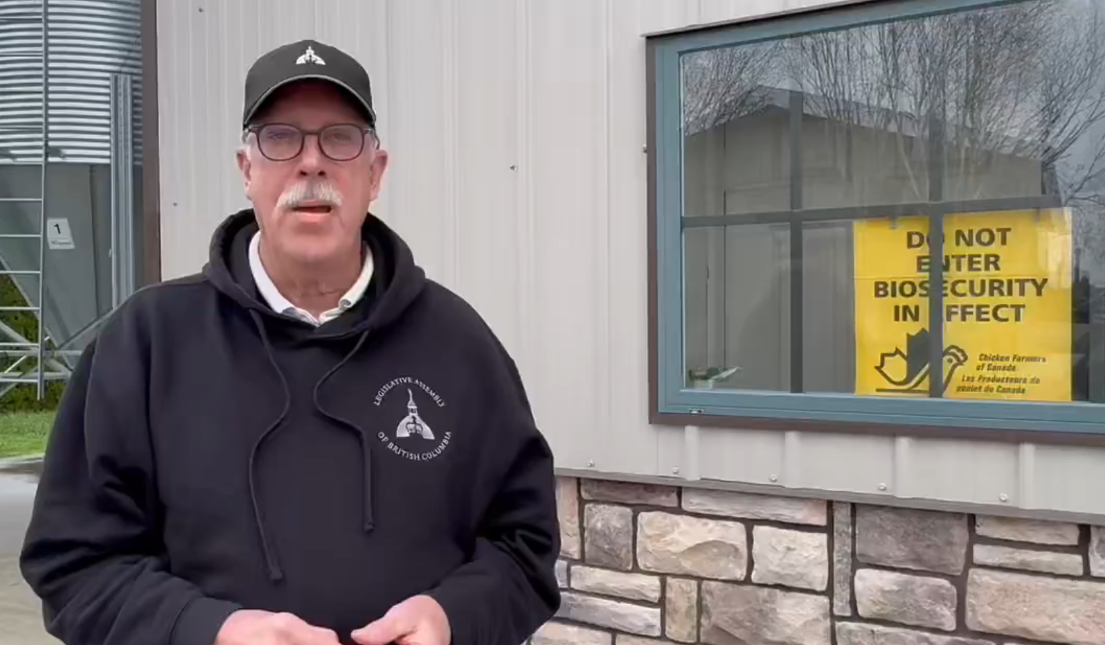 Ian Paton stands in front of a quarantine sign