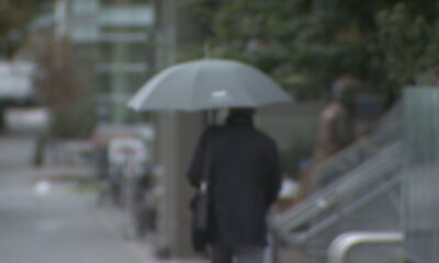 A person walks with an umbrella in the rain in Vancouver.