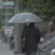 A person walks with an umbrella in the rain in Vancouver.