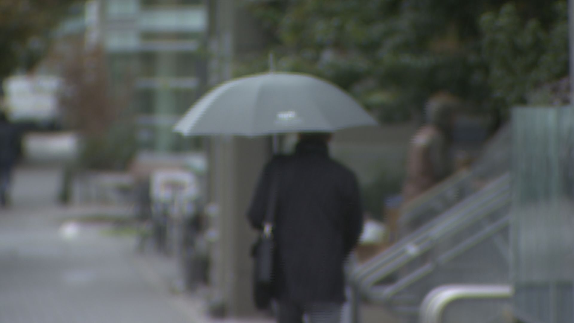 A person walks with an umbrella in the rain in Vancouver.