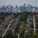 The downtown Vancouver skyline is seen in the distance beyond houses in Burnaby, B.C., on Wednesday, July 12, 2023. (THE CANADIAN PRESS/Darryl Dyck)