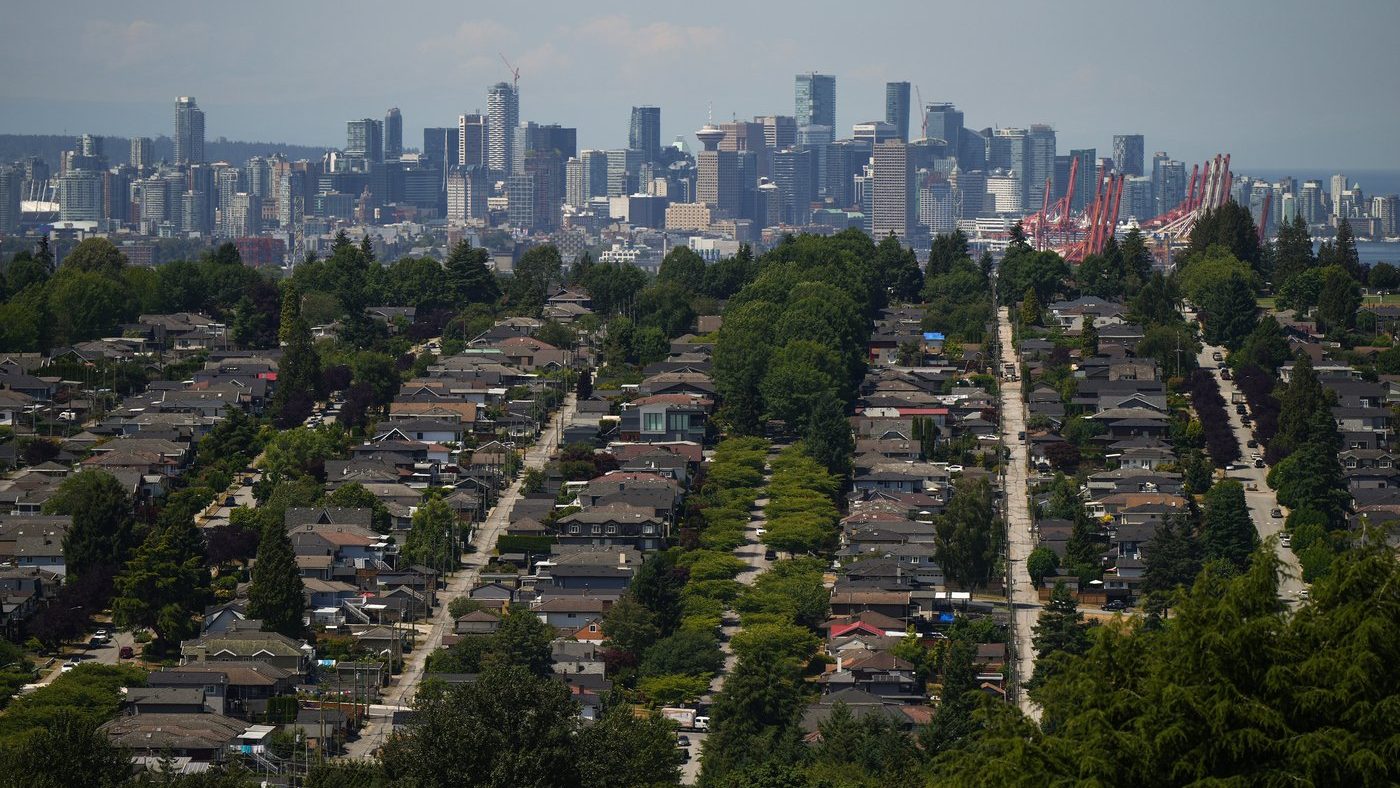 The downtown Vancouver skyline is seen in the distance beyond houses in Burnaby, B.C., on Wednesday, July 12, 2023. (THE CANADIAN PRESS/Darryl Dyck)