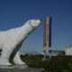 A polar bear statue stands near a road,