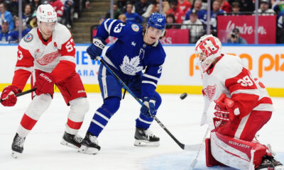 Detroit Red Wings' goaltender Cam Talbot (39) makes a save as Moritz Seider (53) and Toronto Maple Leafs' Matthew Knies (23) look on