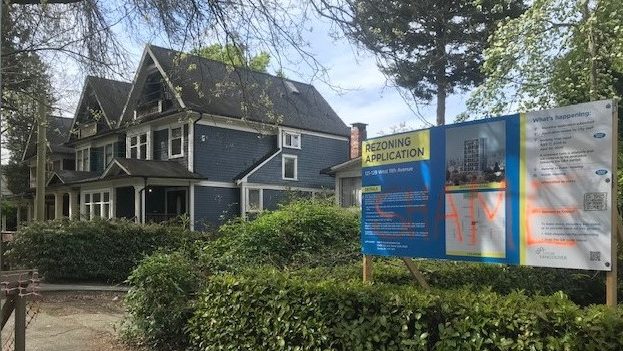 The development board, which has been sprayed with word SHAME, in front of the proposed tower at West 11th Ave.