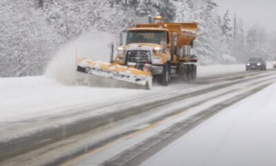 A snow plow is seen on a highway.