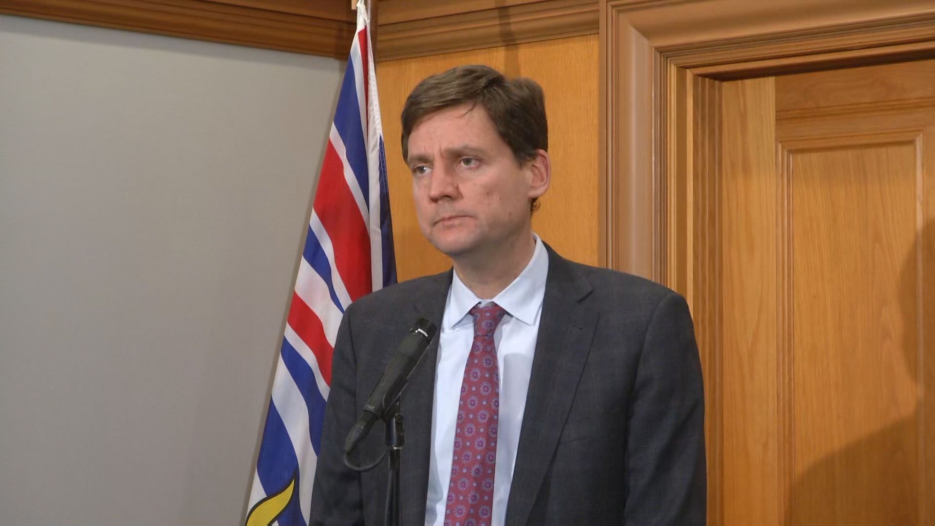 Premier David Eby speaks into a microphone