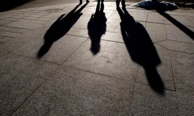 People cast their shadows on the sidewalk