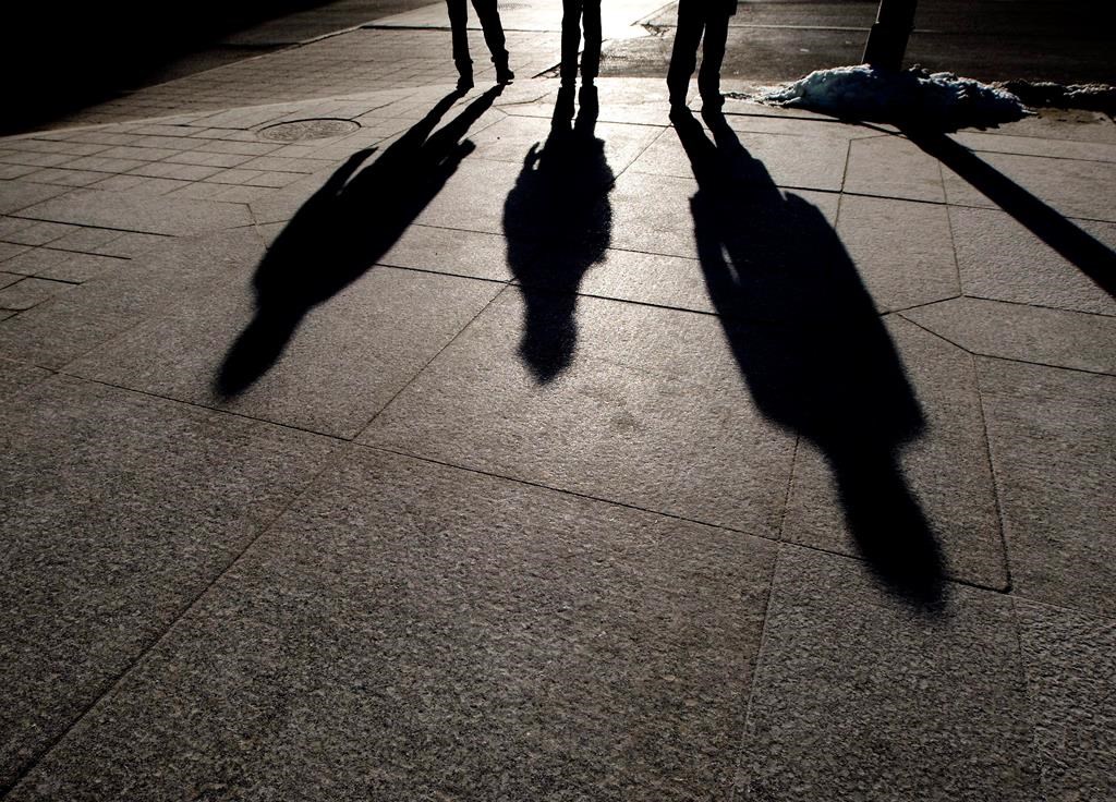 People cast their shadows on the sidewalk