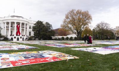 President Joe Biden and first lady Jill Biden walk between AIDS Memorial Quilts spread over the South Lawn of the White House during a ceremony to commemorate World AIDS Day with survivors, their families and advocates, Sunday, Dec. 1, 2024, in Washington.