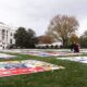 President Joe Biden and first lady Jill Biden walk between AIDS Memorial Quilts spread over the South Lawn of the White House during a ceremony to commemorate World AIDS Day with survivors, their families and advocates, Sunday, Dec. 1, 2024, in Washington.